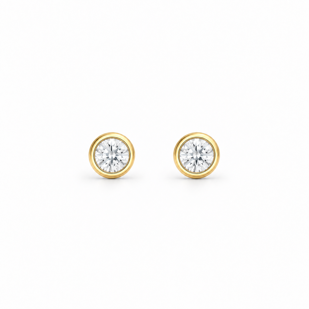 A pair of round-cut moissanite stud earrings in yellow gold bezel settings, by knightley