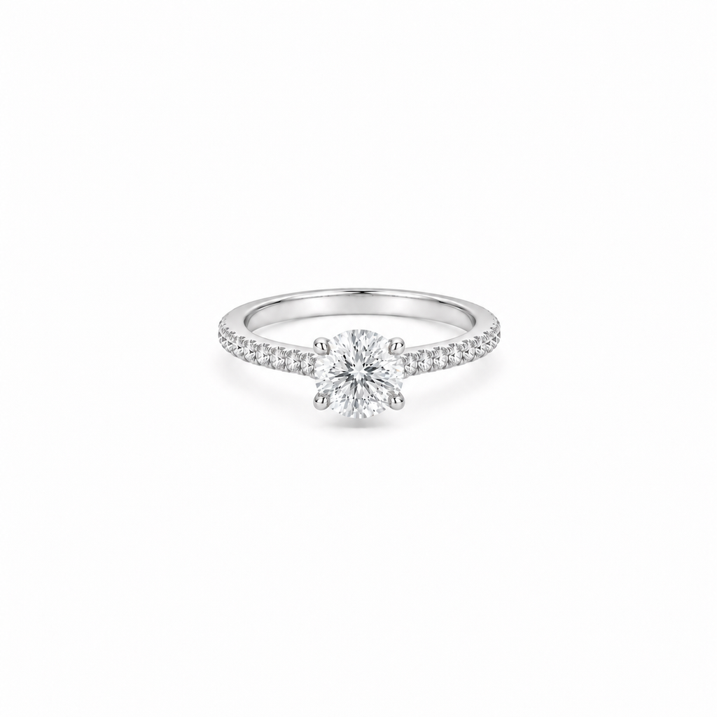 A 1ct round brilliant cut moissanite solitaire ring with a pavé band, white gold plated sterling silver