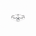 A 1ct round brilliant cut moissanite solitaire ring with a pavé band, white gold plated sterling silver