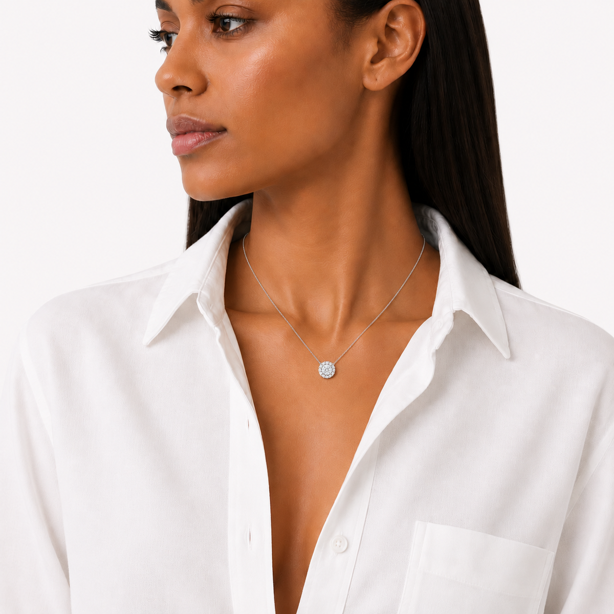 model wearing A round brilliant cut moissanite weighing 1ct is framed by a halo of round brilliant cut moissanite, white gold plated sterling silver