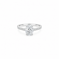 An oval cut moissanite weighing 2ct, accompanied by pavé set stones along the band, white gold plated sterling silver