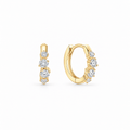 A pair of gold huggie hoop earrings with a row of clear round-cut moissanite stones, yellow gold plated sterling silver. by knightley 