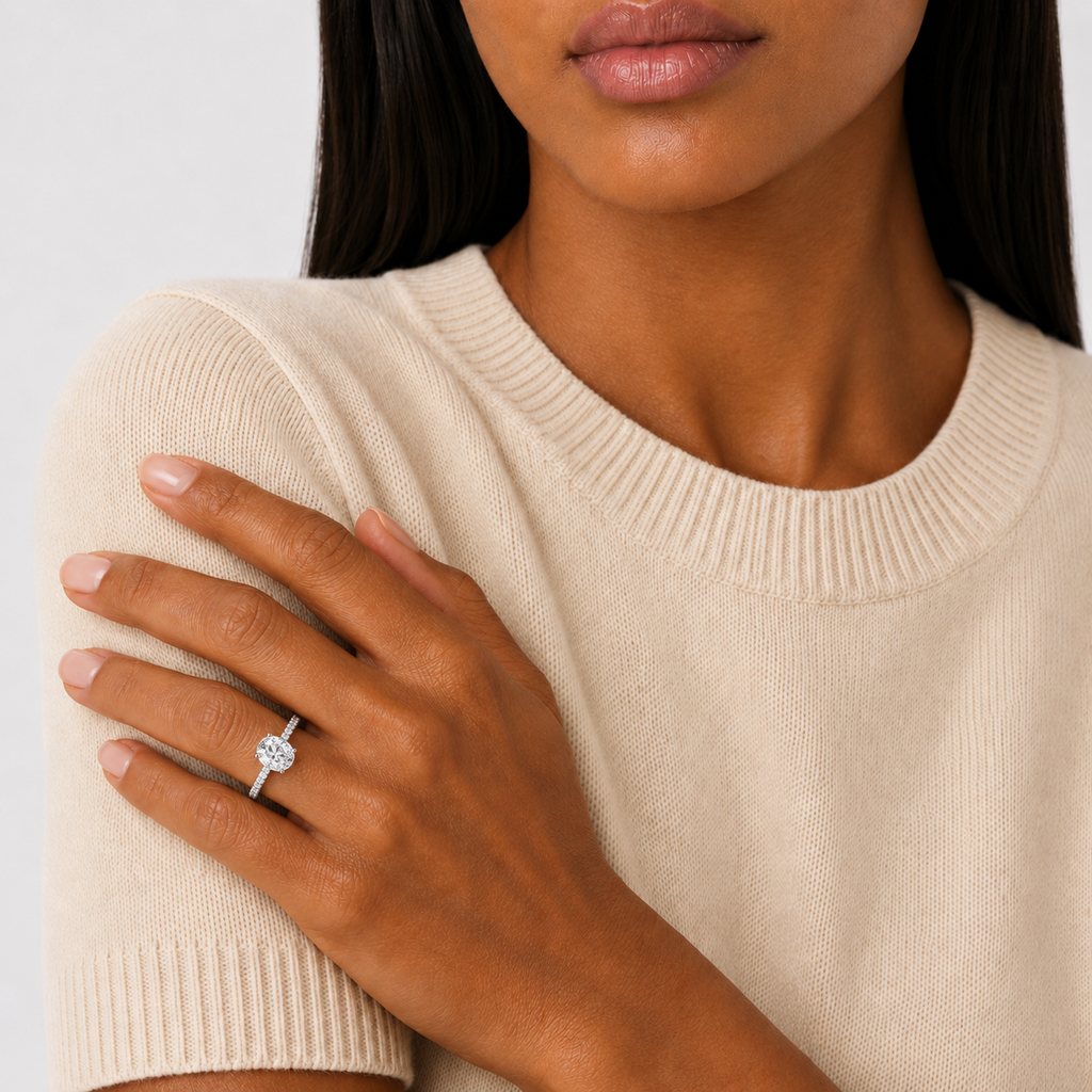A model wearing an oval cut moissanite weighing 2ct, accompanied by pavé set stones along the band, white gold plated sterling silver